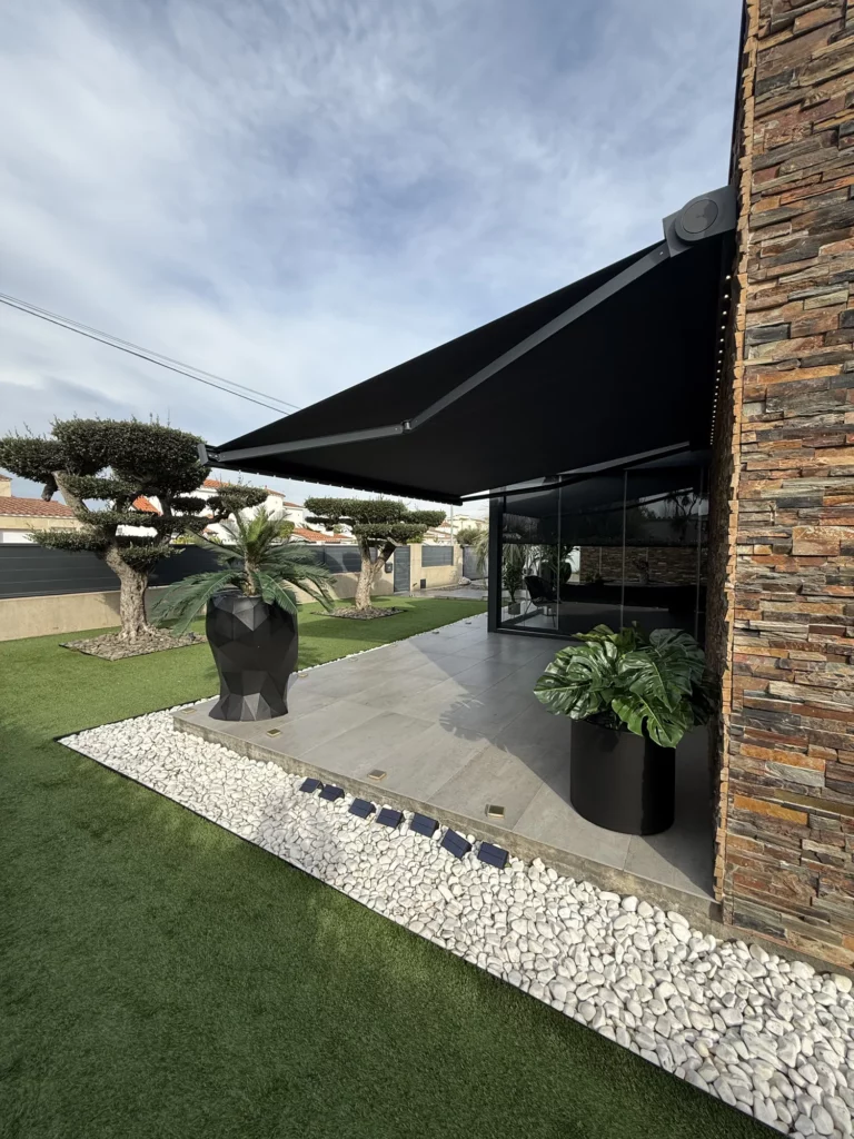 Toldo cofre Gibus con LED en fachada de piedra en Empuriabrava